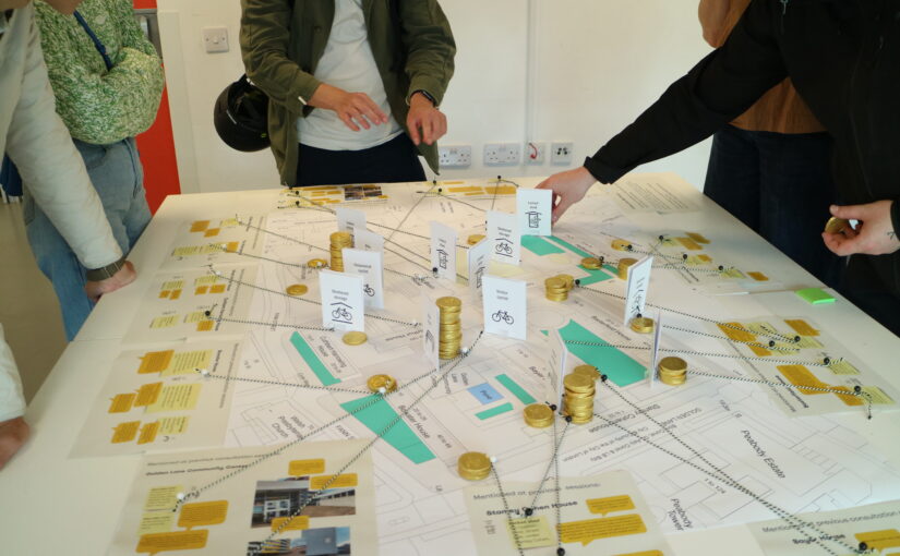 Residents standing round a table with a map of the Golden Lane Estate to give their input about where bike parking could go.