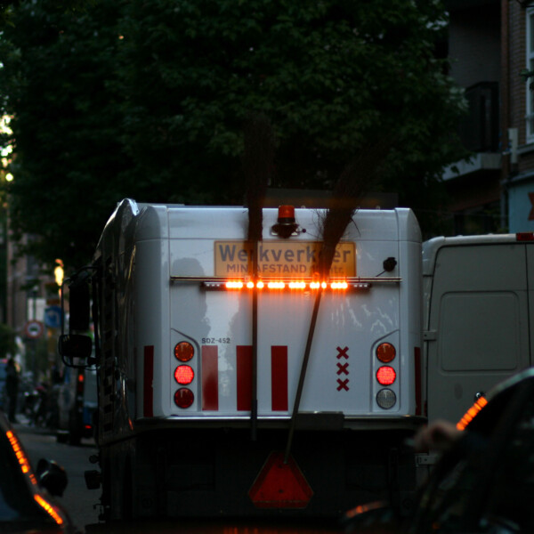 street cleaning truck on street, seen from behind