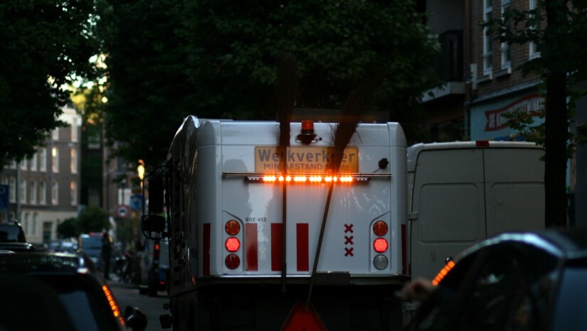 street cleaning truck on street, seen from behind