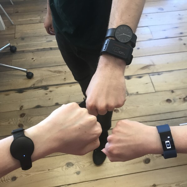 three people showing wrists together with smartwatches on