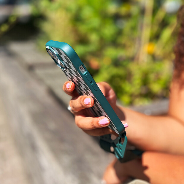 Person sitting outside looking at a smartphone.